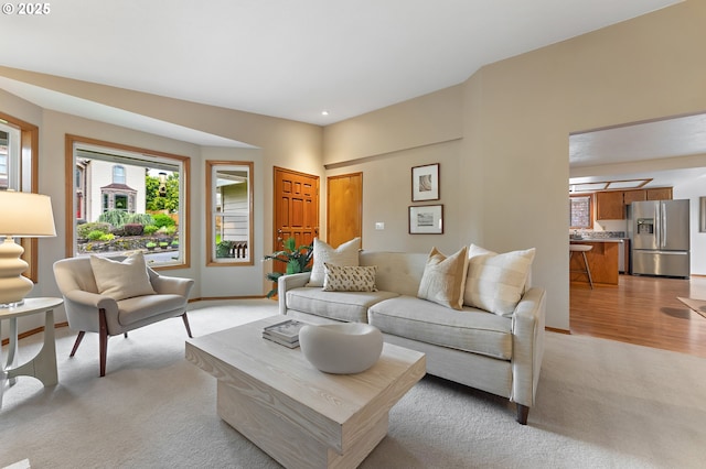 living room featuring recessed lighting, baseboards, and light carpet
