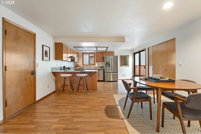 dining room featuring baseboards and light wood-style flooring
