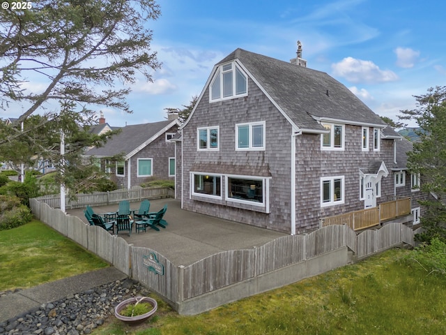 1021 S Prom, Seaside, OR 97138 - back of property featuring a shingled roof, a patio, and a chimney
