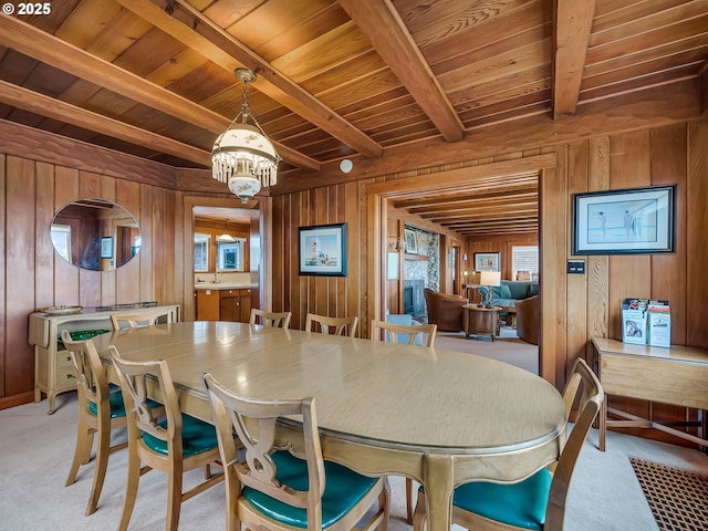 1021 S Prom, Seaside, OR 97138 - dining room with wood walls, wooden ceiling with exposed beams, a chandelier, and light carpet