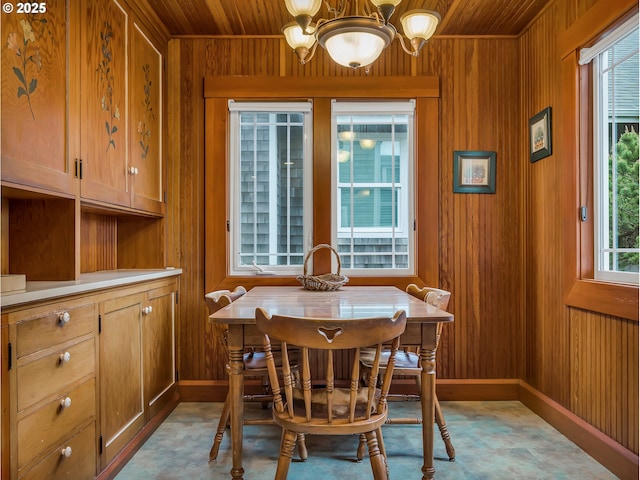 1021 S Prom, Seaside, OR 97138 - dining space featuring wood ceiling, a chandelier, wood walls, and baseboards