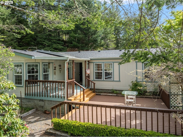 view of front of house featuring a shingled roof, a porch, and a deck