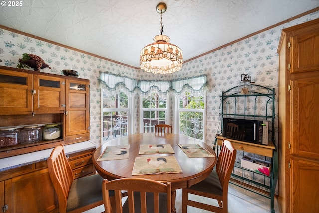 dining room featuring crown molding, wallpapered walls, wood finished floors, and a notable chandelier