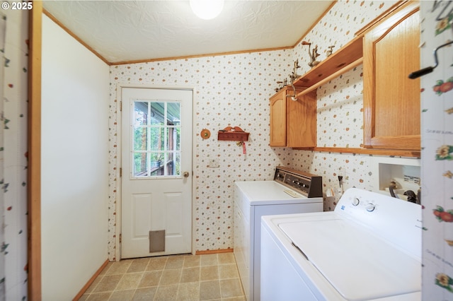 laundry area with crown molding, baseboards, cabinet space, and washing machine and clothes dryer
