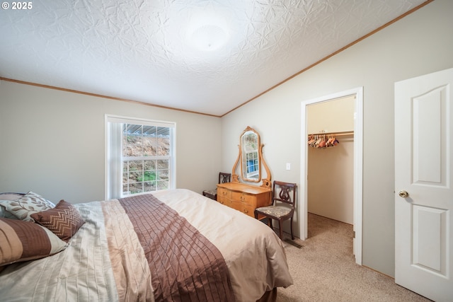 bedroom with crown molding, light colored carpet, vaulted ceiling, a spacious closet, and a closet