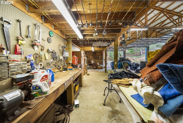 miscellaneous room with a workshop area and concrete floors
