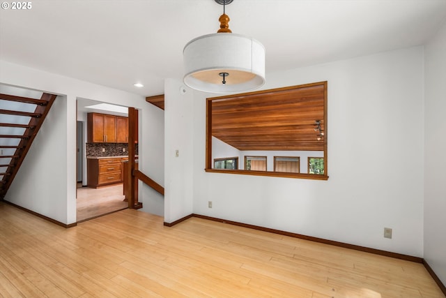 spare room with stairway, baseboards, recessed lighting, and light wood-style flooring