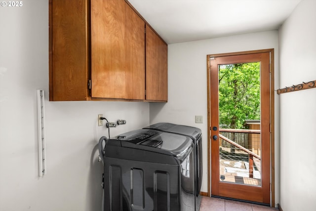 laundry area with cabinet space, separate washer and dryer, and light tile patterned floors