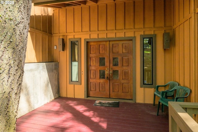 entrance to property with a wooden deck and board and batten siding