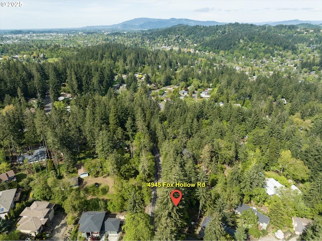 aerial view featuring a forest view and a mountain view