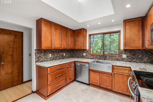 kitchen with brown cabinetry, a sink, recessed lighting, and stainless steel appliances