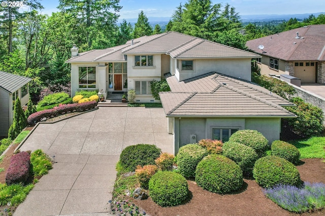 369 NW 81st Pl, Portland, OR 97229 - view of front of property with stucco siding, a tile roof, and a chimney