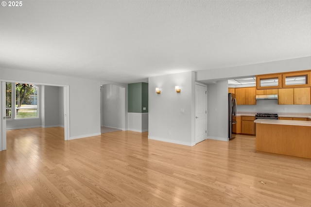 unfurnished living room featuring light wood-style flooring and baseboards