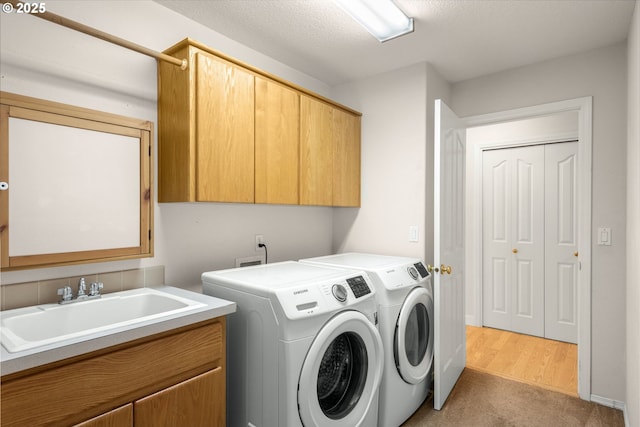 laundry area with cabinet space, carpet flooring, separate washer and dryer, and a sink