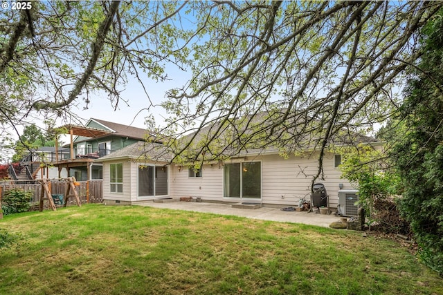 back of property with a patio, fence, a lawn, and central AC unit