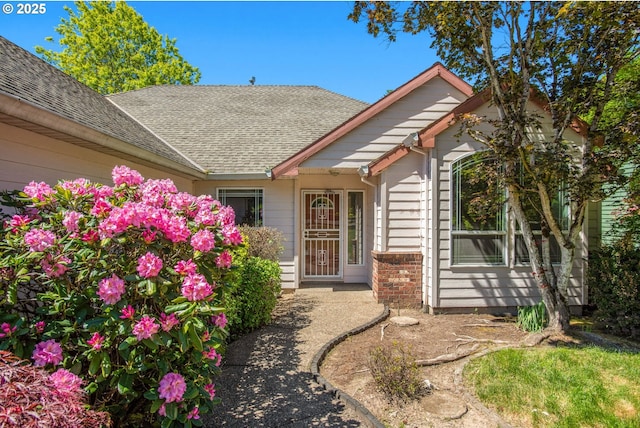 property entrance featuring a shingled roof