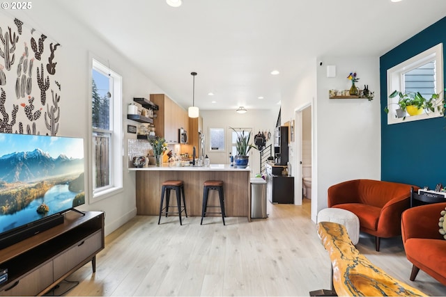 kitchen featuring recessed lighting, open shelves, light wood-style flooring, and a peninsula
