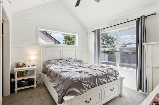 carpeted bedroom with wooden walls, a water view, multiple windows, and lofted ceiling