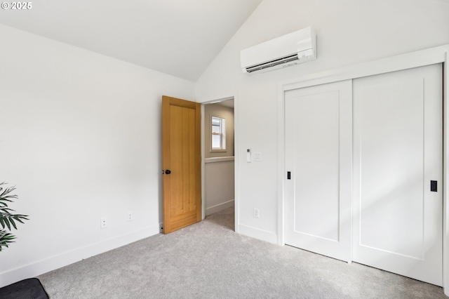 unfurnished bedroom featuring baseboards, a wall mounted AC, carpet, and a closet