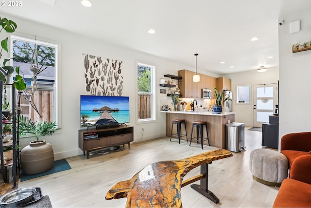 living area with plenty of natural light, recessed lighting, and light wood-style floors