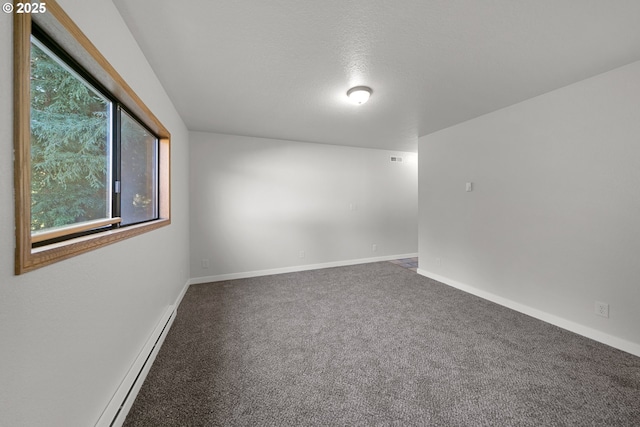 empty room featuring carpet flooring, a textured ceiling, and a baseboard heating unit