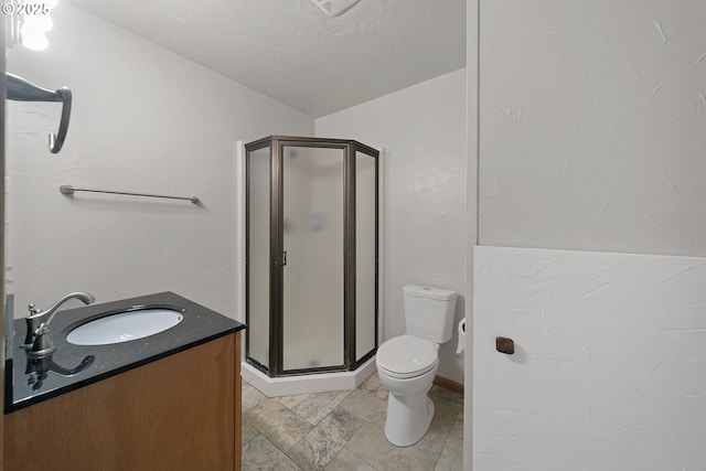 bathroom featuring vanity, an enclosed shower, a textured ceiling, and toilet