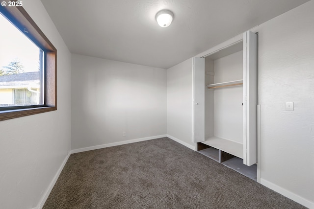 unfurnished bedroom featuring a closet and dark colored carpet