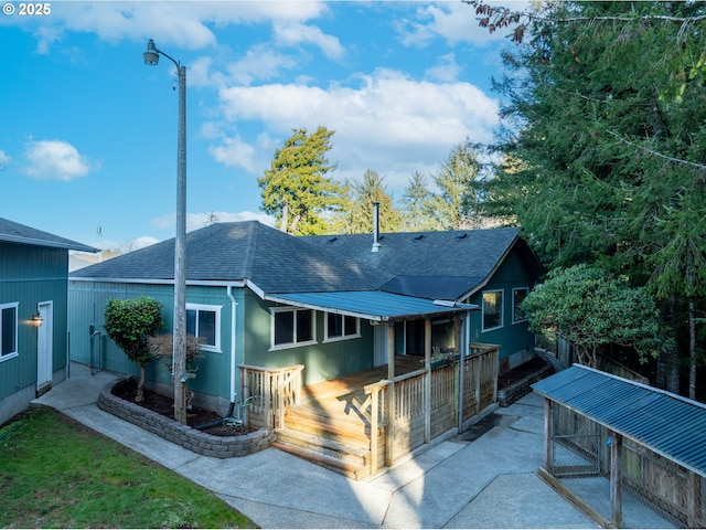 rear view of house featuring a wooden deck