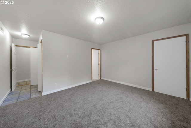 carpeted empty room featuring a textured ceiling