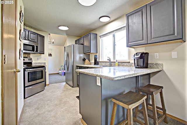 425 Warner St, Oregon City, OR 97045 - kitchen with stainless steel appliances, a sink, light colored carpet, a peninsula, and baseboards