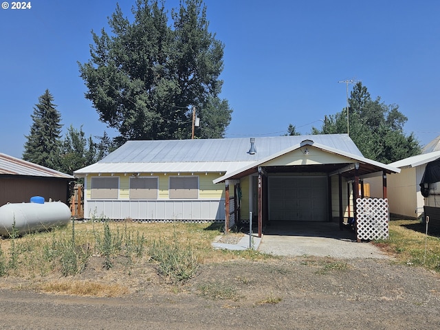 view of front of house with a garage, a carport, and metal roof