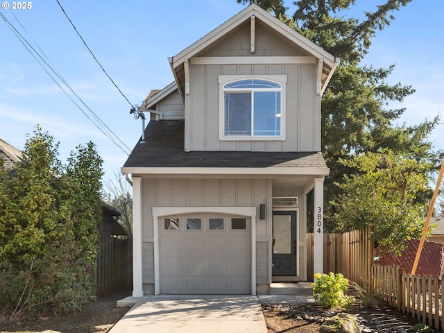 traditional-style house with board and batten siding, concrete driveway, fence, and a garage