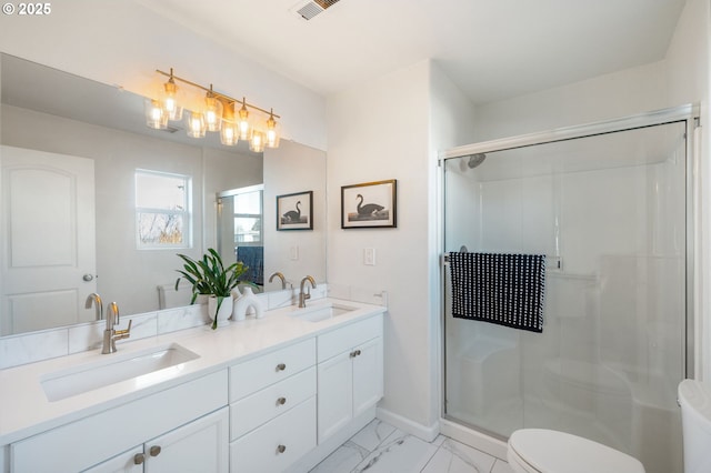 bathroom with marble finish floor, a sink, a shower stall, and toilet