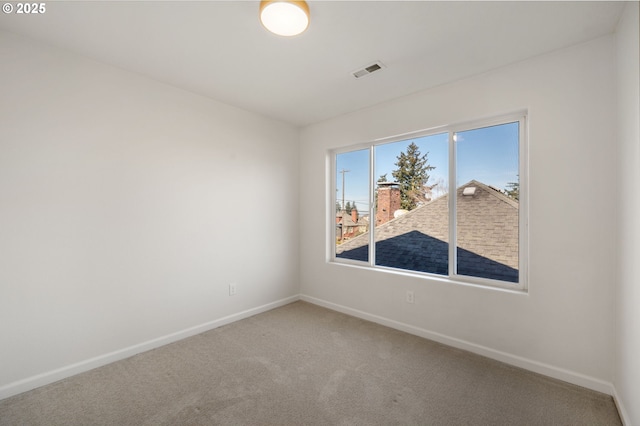 carpeted empty room featuring visible vents and baseboards