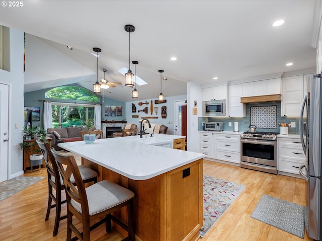 18495 Terry Ave, Lake Oswego, OR 97035 - kitchen with appliances with stainless steel finishes, light countertops, a ceiling fan, open floor plan, and custom exhaust hood