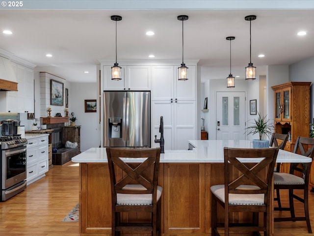 18495 Terry Ave, Lake Oswego, OR 97035 - kitchen featuring hanging light fixtures, light wood-type flooring, light countertops, stainless steel appliances, and white cabinetry
