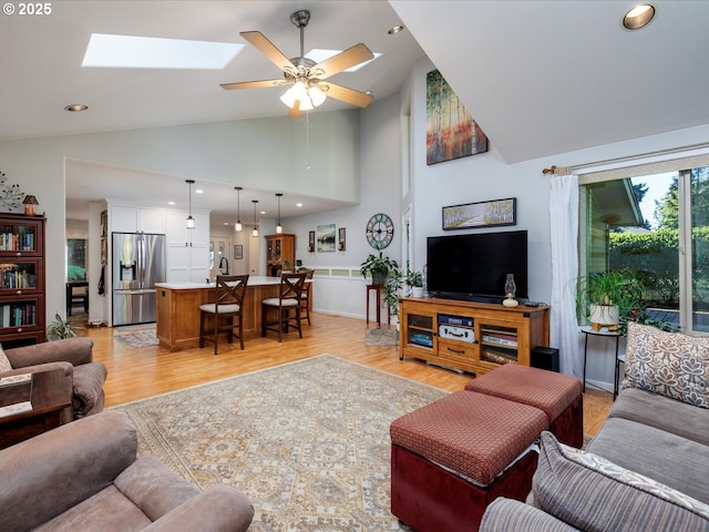 18495 Terry Ave, Lake Oswego, OR 97035 - living room featuring ceiling fan, a skylight, high vaulted ceiling, and light wood-type flooring