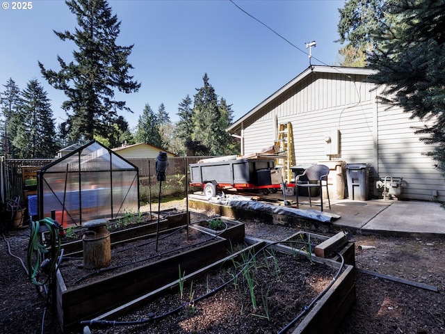 18495 Terry Ave, Lake Oswego, OR 97035 - view of yard featuring fence, an outdoor structure, a greenhouse, and a vegetable garden