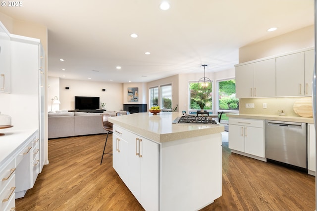 9030 SW Lancelot Ln, Portland, OR 97219 - kitchen with appliances with stainless steel finishes, wood finished floors, white cabinetry, light countertops, and recessed lighting