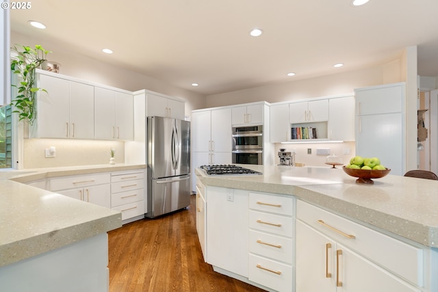 9030 SW Lancelot Ln, Portland, OR 97219 - kitchen with stainless steel appliances, recessed lighting, light stone countertops, white cabinetry, and dark wood finished floors