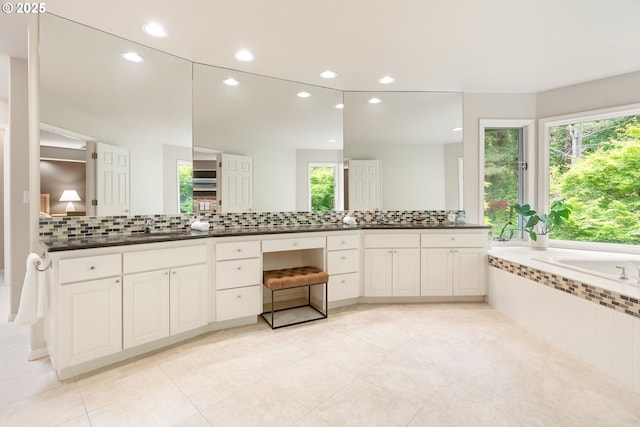 full bath with recessed lighting, backsplash, vanity, tiled bath, and tile patterned floors
