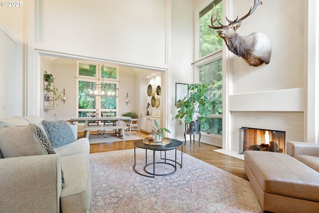 9030 SW Lancelot Ln, Portland, OR 97219 - living room featuring a high ceiling, wood finished floors, and a fireplace with flush hearth