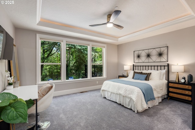 carpeted bedroom with a ceiling fan, a textured ceiling, visible vents, a raised ceiling, and baseboards