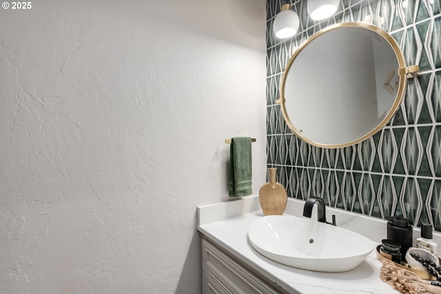 bathroom featuring a textured wall and vanity