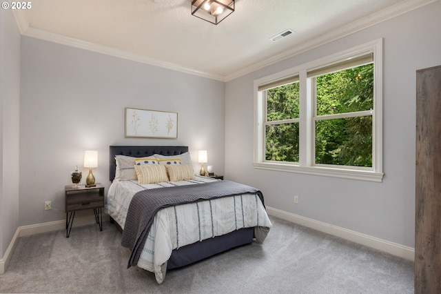 carpeted bedroom with baseboards, ornamental molding, and visible vents