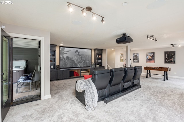 carpeted cinema featuring rail lighting and baseboards