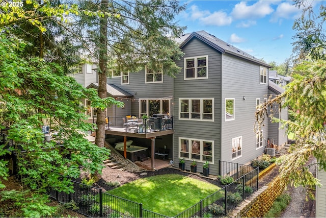 back of property with a lawn, a deck, a fenced backyard, and central air condition unit