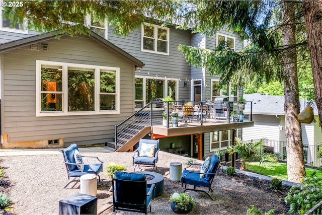 back of house with a patio, an outdoor fire pit, a wooden deck, and stairs