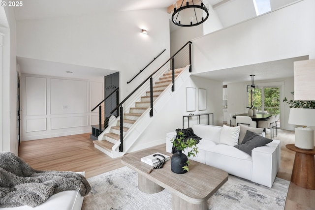 8616 SW 49th Ave, Portland, OR 97219 - living area featuring a high ceiling, light wood-type flooring, stairway, and a chandelier