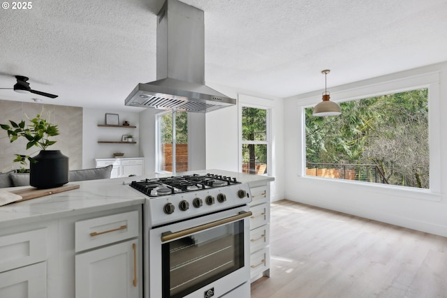 8616 SW 49th Ave, Portland, OR 97219 - kitchen with gas range gas stove, range hood, a textured ceiling, light stone countertops, and white cabinets